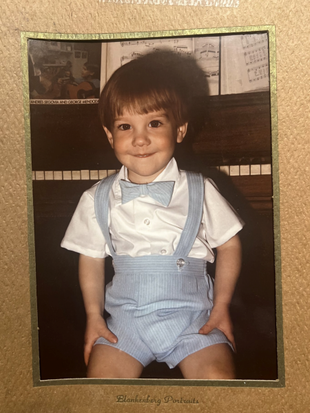 Baby Phil C-B smiling wide sitting at the piano.
